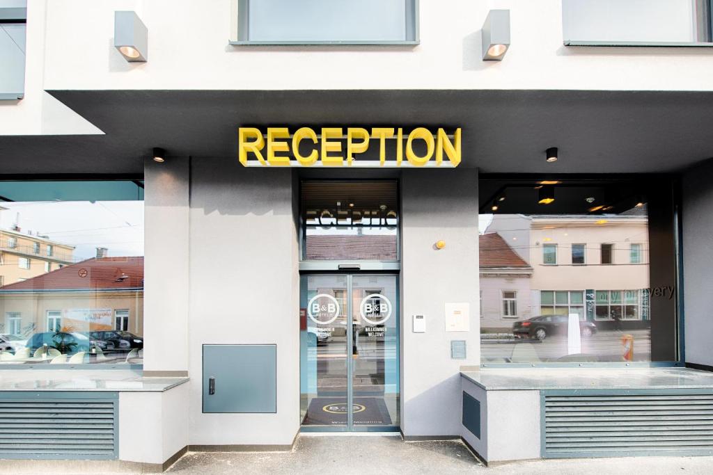 a store front with a sign that reads reception at B&B Hotel Wien-Meidling in Vienna