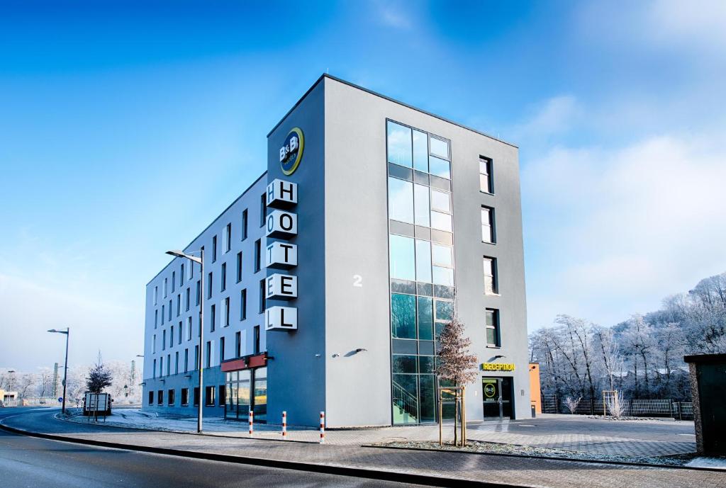 un bâtiment blanc avec une horloge sur son côté dans l'établissement B&B Hotel Wetzlar, à Wetzlar