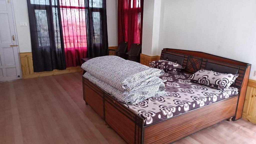 ein Schlafzimmer mit einem Bett in einem Zimmer mit Fenstern in der Unterkunft Shanti Jungle cottage in Mashobra