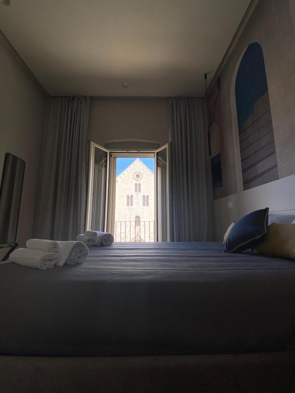 a bedroom with a large bed with a large window at Nonno Nicola Rooms in Bari