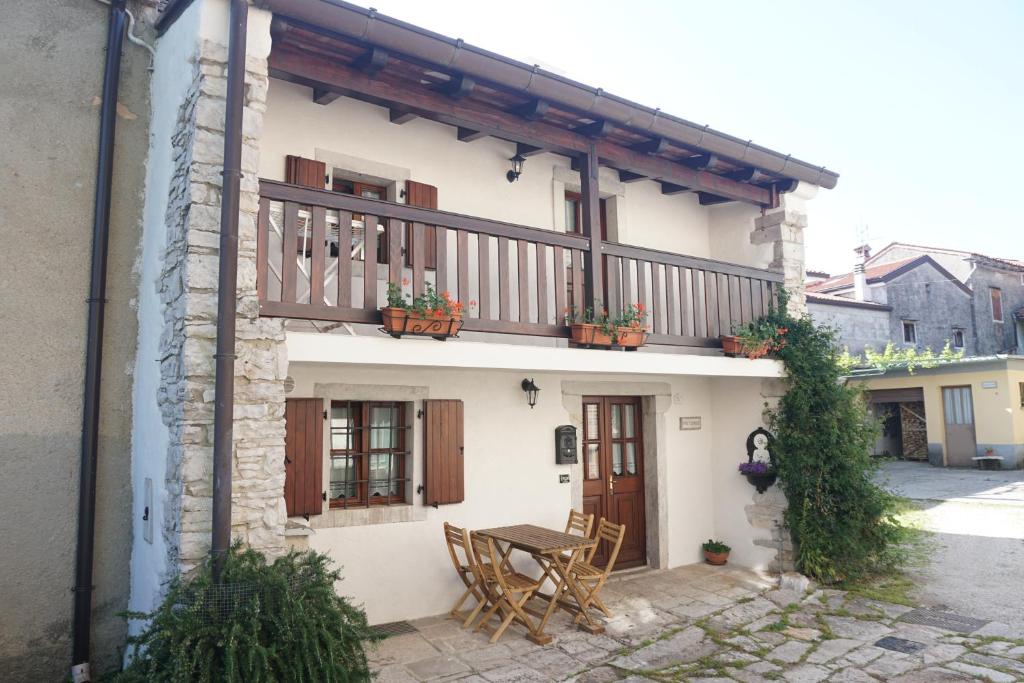 un edificio con balcón con mesa y sillas en Casa Vacanze Alenka, en Borgo Grotta Gigante