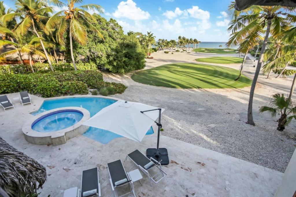 an overhead view of a pool with chairs and an umbrella at Caleton 16 Ocean view 5 bedroom villa with Chef Butler Maid Golf Cart in Punta Cana