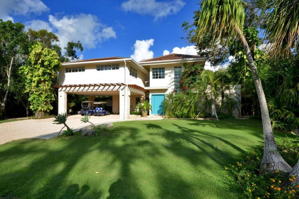 una gran casa blanca con un patio verde en Villa Careta Tortuga B55, en Punta Cana