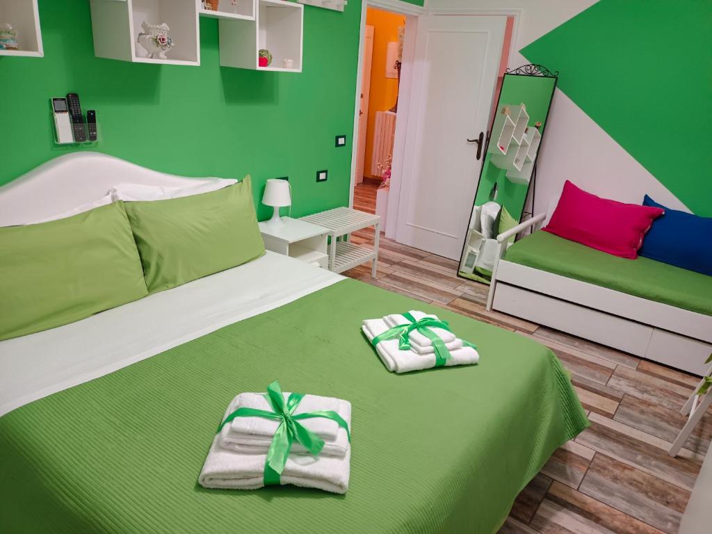 Habitación verde con 2 camas y toallas. en appartamento in firenze la lamma, en Florencia