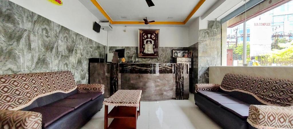 - un salon avec deux canapés et une cheminée dans l'établissement Sarovara Deluxe Rooms, à Chennai