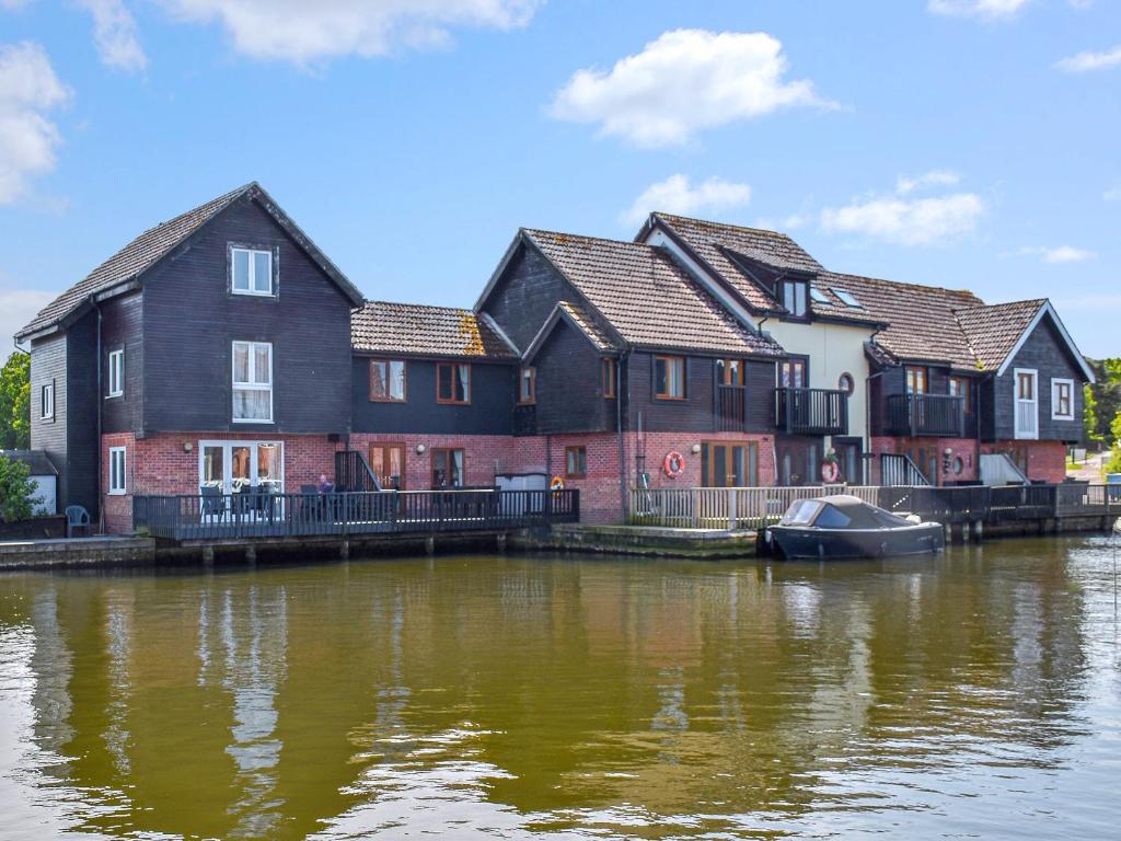a row of houses next to a river at Lilys Cottage in Wroxham