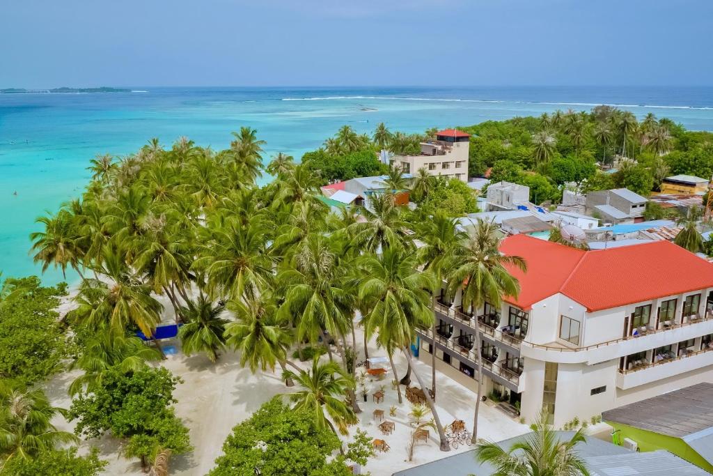 an aerial view of a resort with palm trees and the ocean at Kaani Beach Hotel in Maafushi