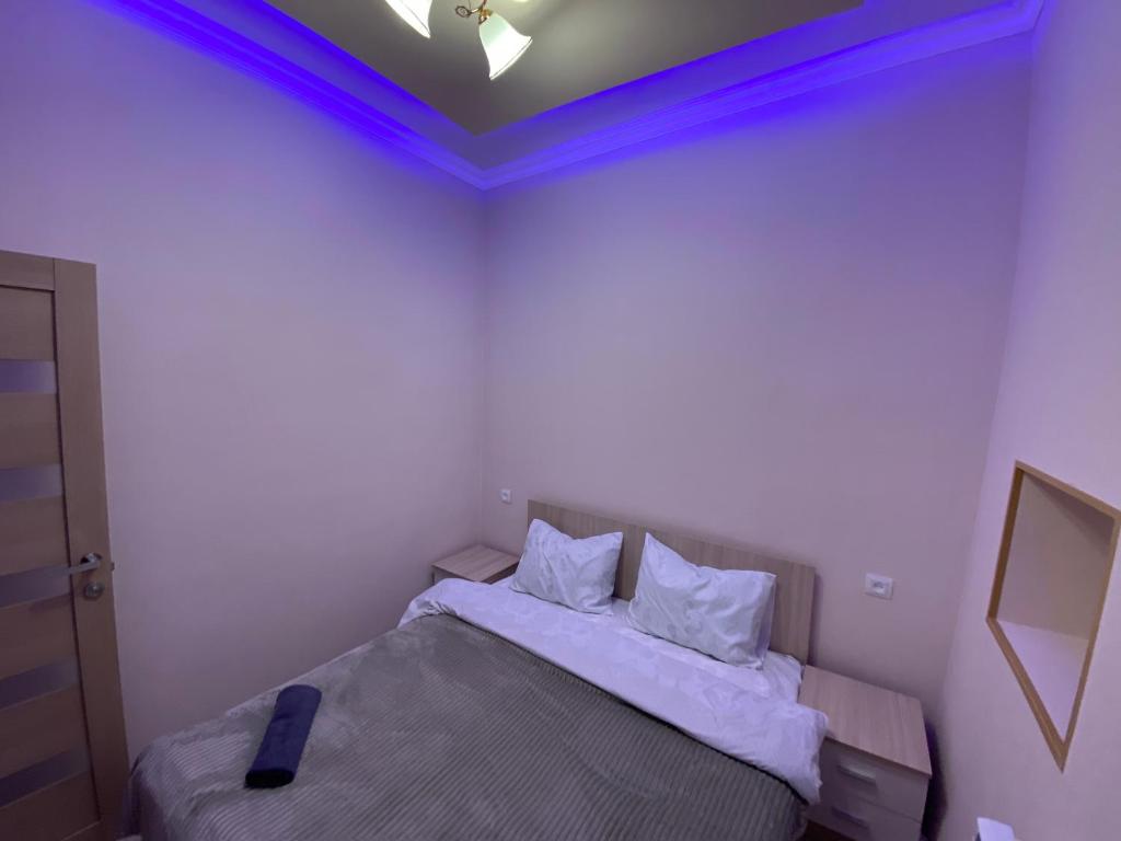 una camera da letto con un letto con luci blu sul soffitto di KosMos Guest House a Gyumri