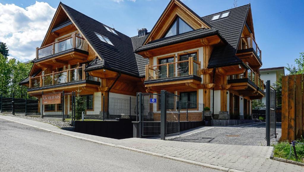 a large wooden house on the side of a street at Aparthotel Merynos in Zakopane