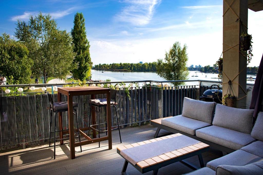 einen Balkon mit einem Tisch und Stühlen sowie Flussblick in der Unterkunft Danuberoom in Wien