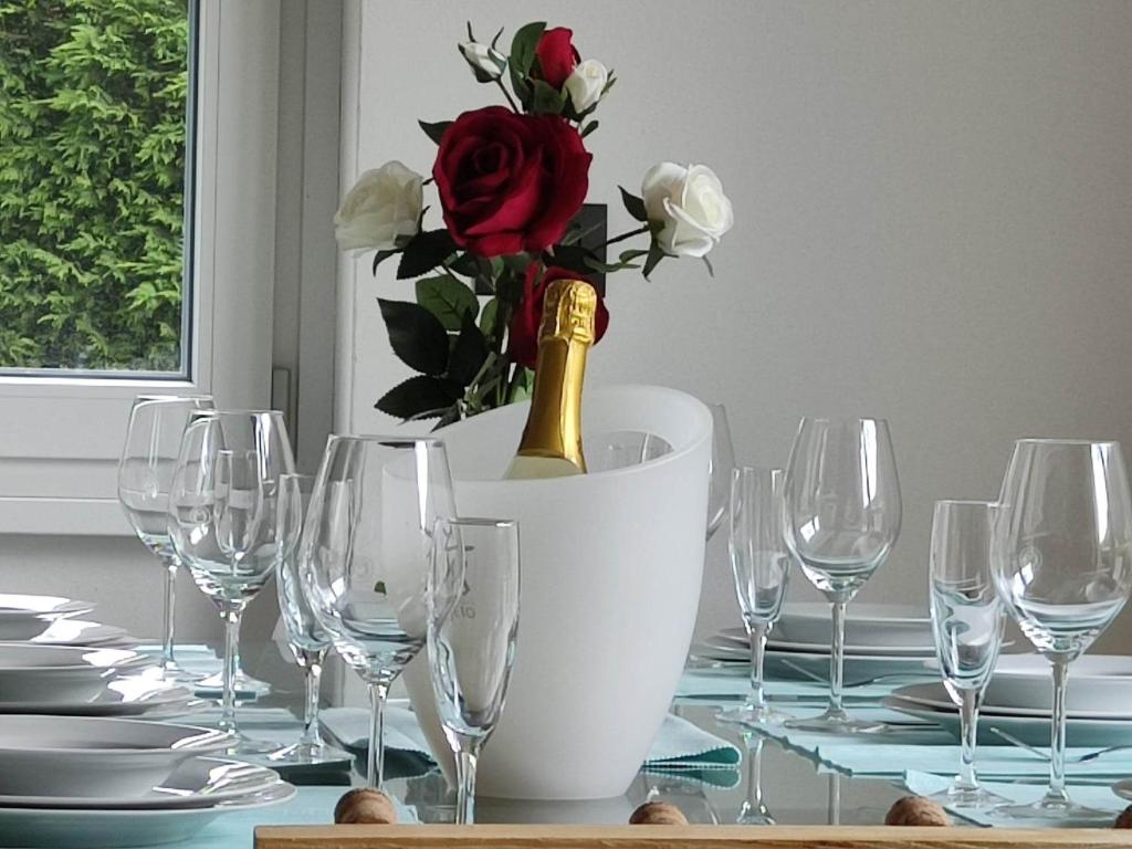 a table with wine glasses and a bottle of champagne at Tirano Express Luxury Appartamento rialzato con vista giardino, barbecue e comfort esclusivo in Tirano