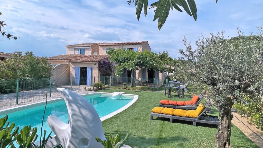 une cour arrière avec une piscine et une maison dans l'établissement Mazets du Soleil, à Sainte-Maxime