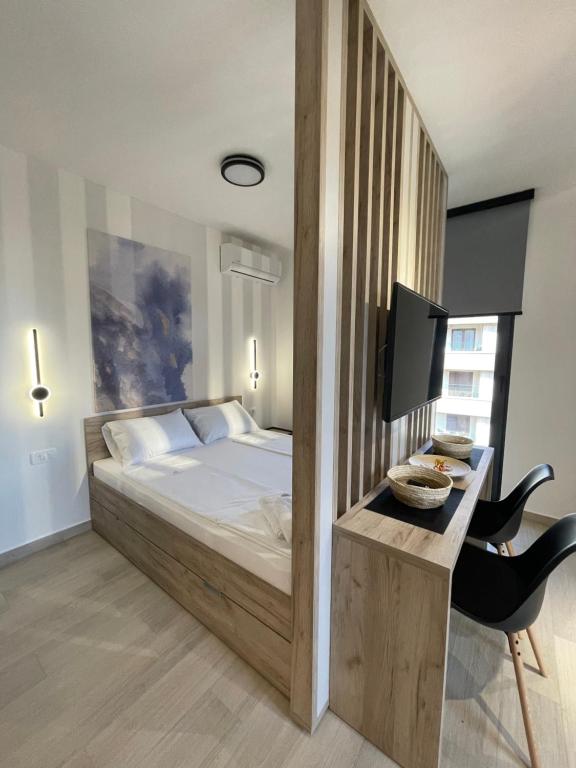 1 dormitorio con 1 cama y escritorio con TV en Dora Family Apartments Budva, en Budva
