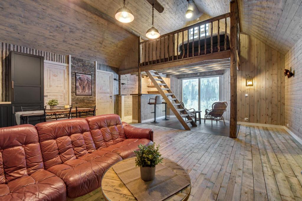 sala de estar con sofá marrón y escalera en Granheim en Namsskogan