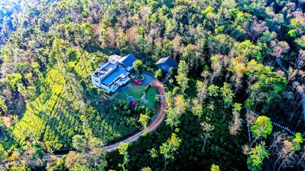 an aerial view of a house in the middle of a forest at Villa Tesori - Holiday home overlooking a river & waterfalls in Meppādi