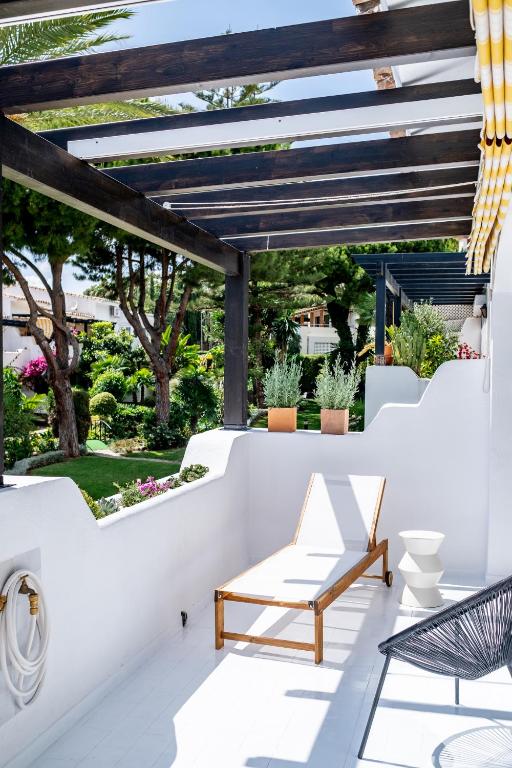 a patio with a bench and a pergola at Golden Mile Designer Penthouse in Marbella