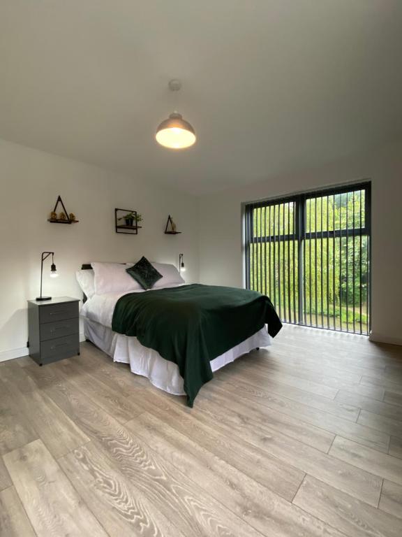 a bedroom with a bed and a large window at Elegant 4 Bedroom, 5 bathroom House in Northampton by HP Accommodation in Watford