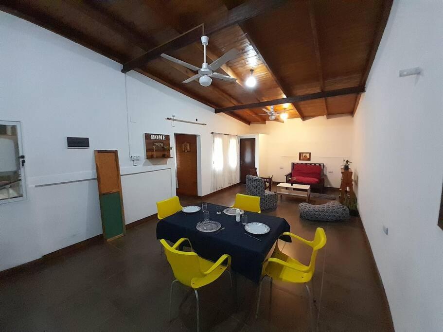 uma sala de estar com uma mesa e cadeiras amarelas em La casa de MaCa em Posadas
