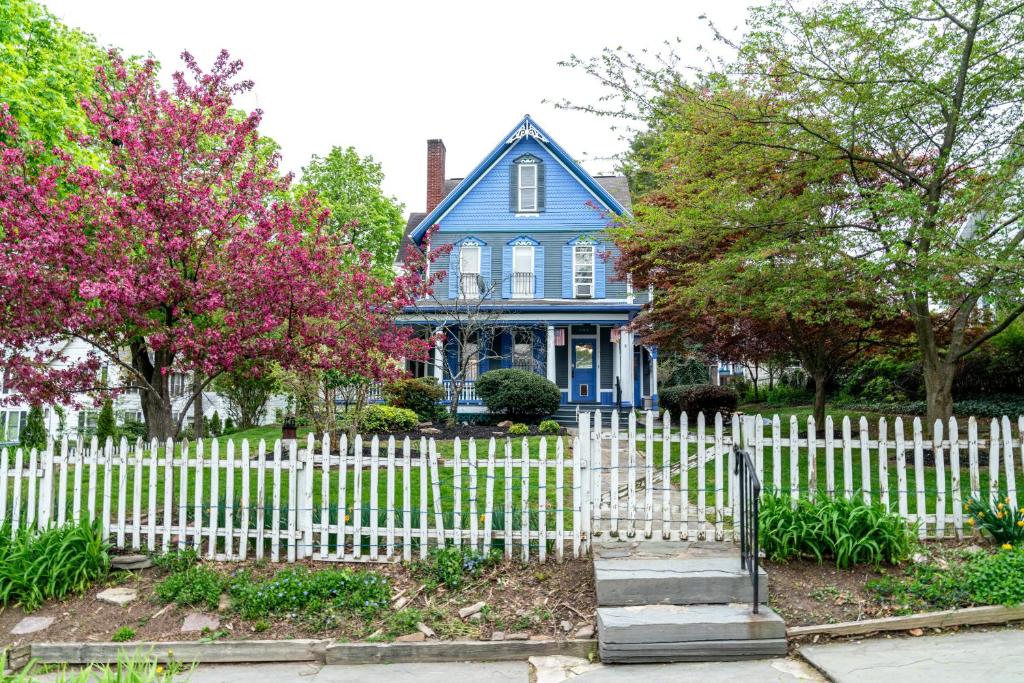 a white picket fence in front of a blue house at CHARMING EXECUTIVE VICTORIAN MANSION w/ FREE PARKING - near Bucknell in Milton