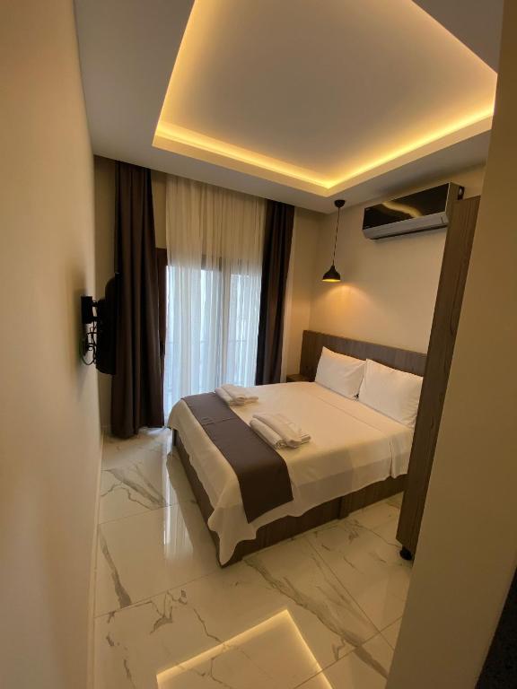 1 dormitorio con cama y ventana grande en Tuna BUTİK OTEL, en Bodrum City
