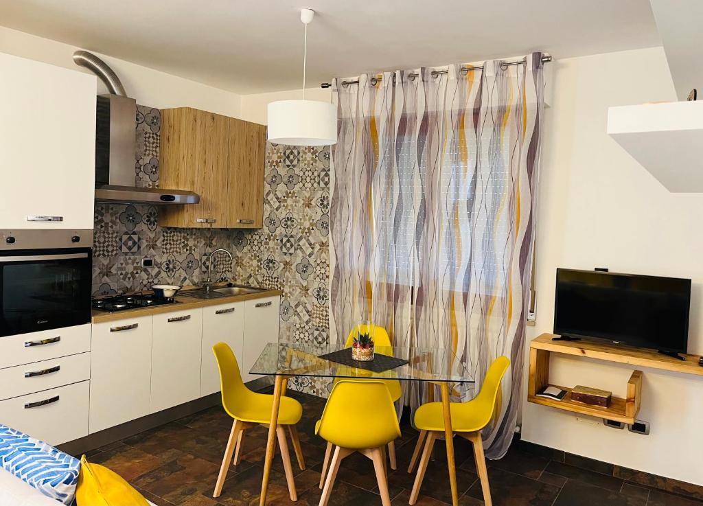 a kitchen with a dining table and yellow chairs at Giramondo in Senigallia