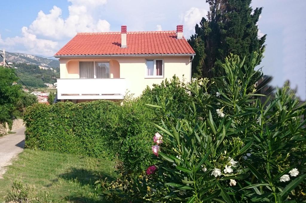 a white house with a red roof at Guest House Violeta in Rab