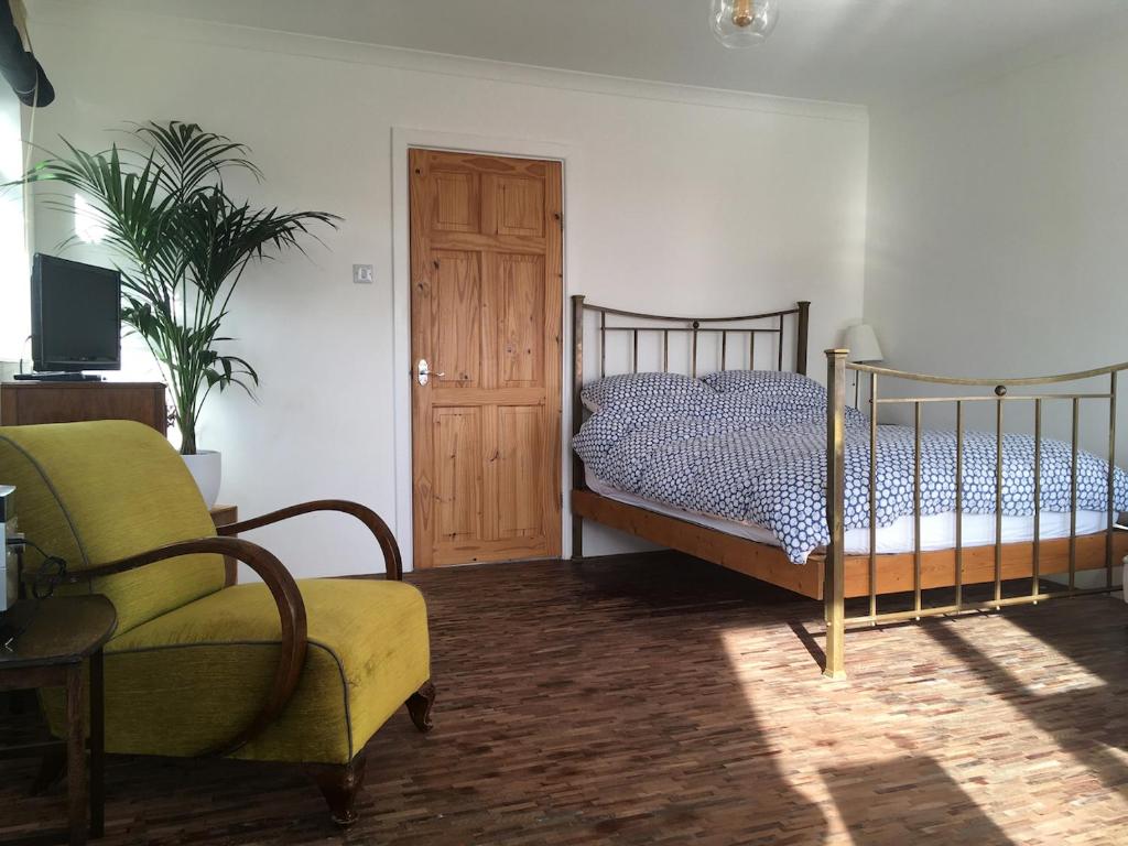 a bedroom with a bed and a chair at Paradise Heights in West Bay