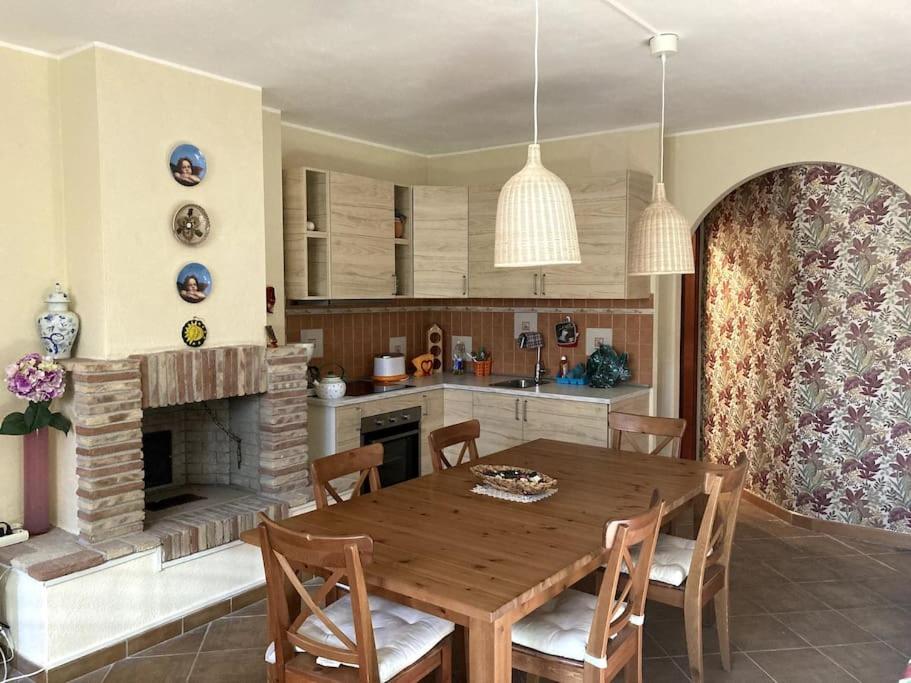 a kitchen with a wooden table and a fireplace at Grazioso appartamento tra Roma e il mare in Rome