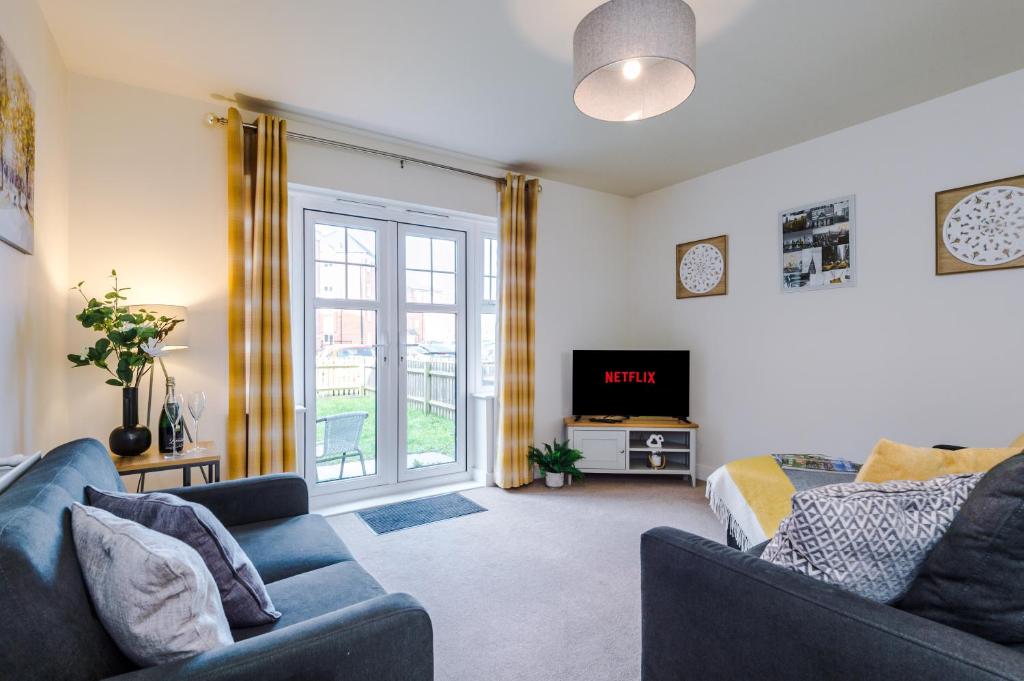 een woonkamer met een bank en een tv bij Spacious 4-Bed Townhouse in Crewe by 53 Degrees Property, Ideal for Contractors & Business, FREE Parking - Sleeps 8 in Crewe