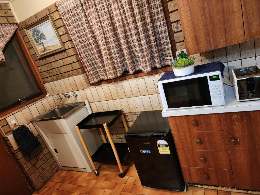 a kitchen with a microwave on top of a counter at Beachfront House in Marengo