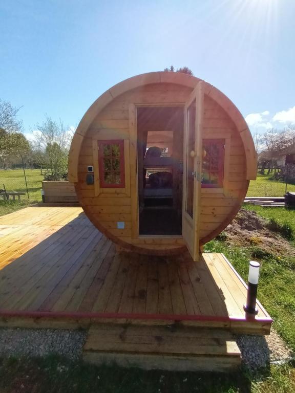 a round wooden cabin with a door on a deck at Les Cabanes d'Hérande - Le Millésime in Fouchères