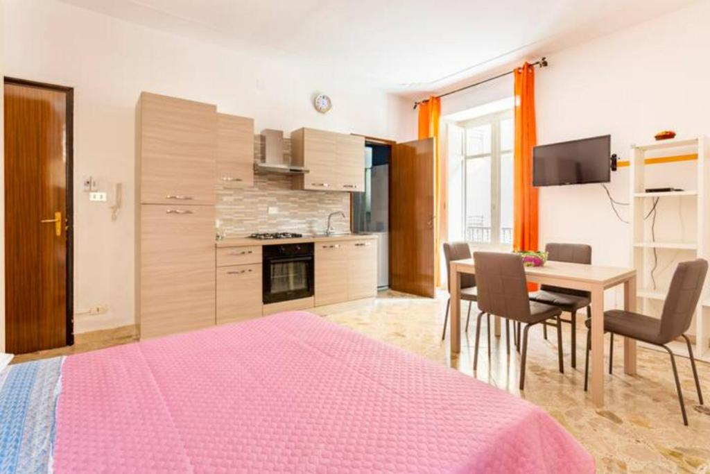 a kitchen and dining room with a pink bed in a room at Casa Antonella in Trabia
