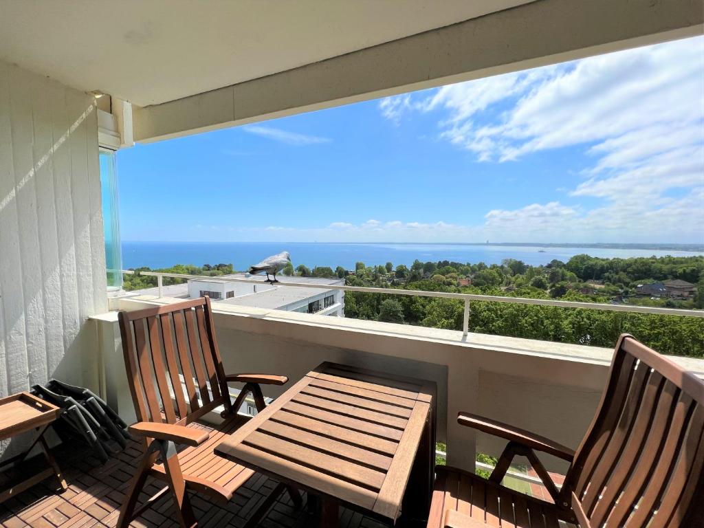 - deux chaises et une table sur un balcon avec vue sur l'océan dans l'établissement Panoramic App B10-7, à Sierksdorf