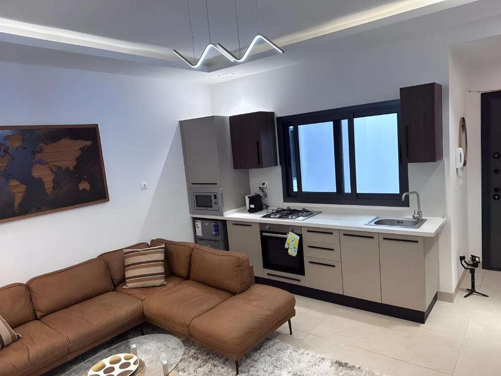 a living room with a couch and a kitchen at Studio Haut standing de dernière génération in Dakar