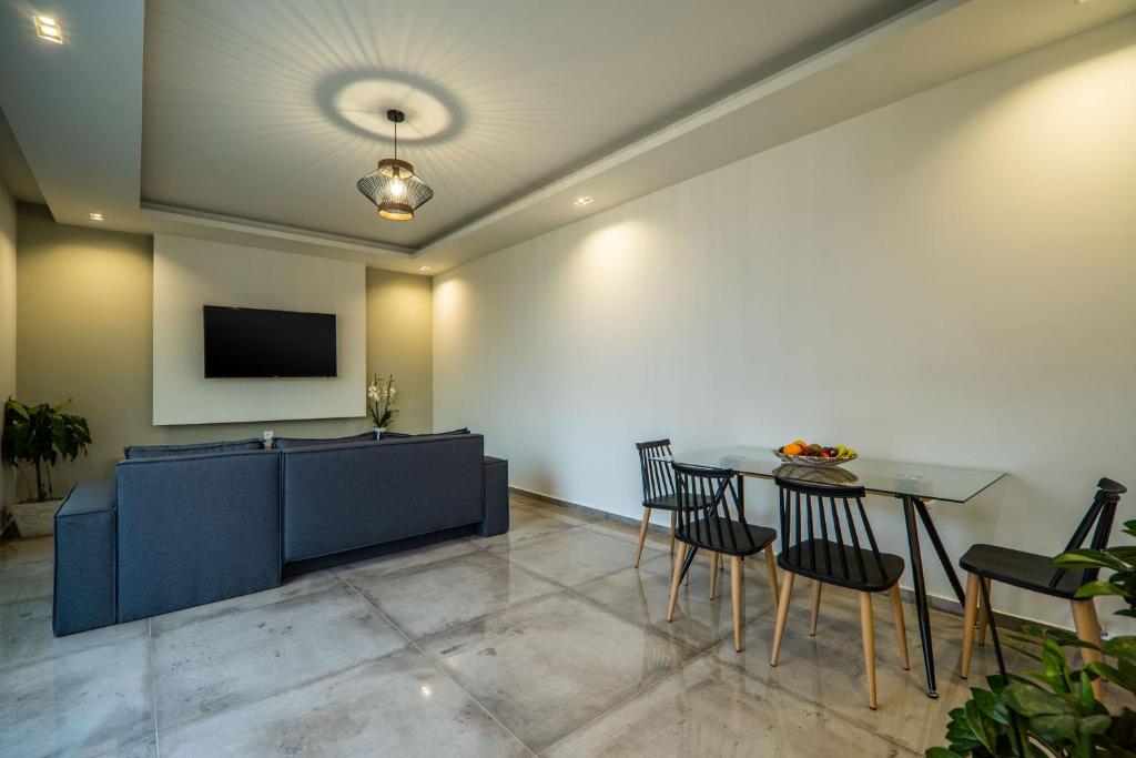 a living room with a table and a tv at Jarko Luxury Houses in Argoulidhés