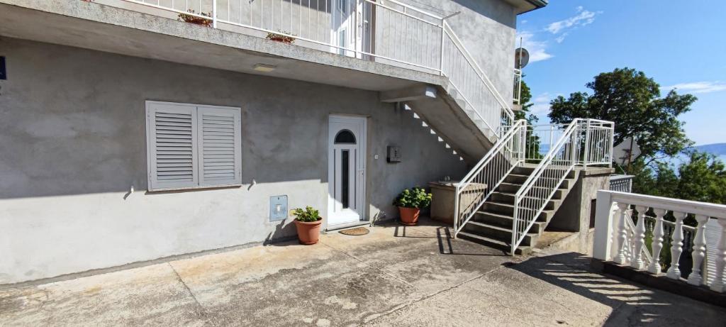 a stairway leading to a building with potted plants at Apartment Biondic in Senj