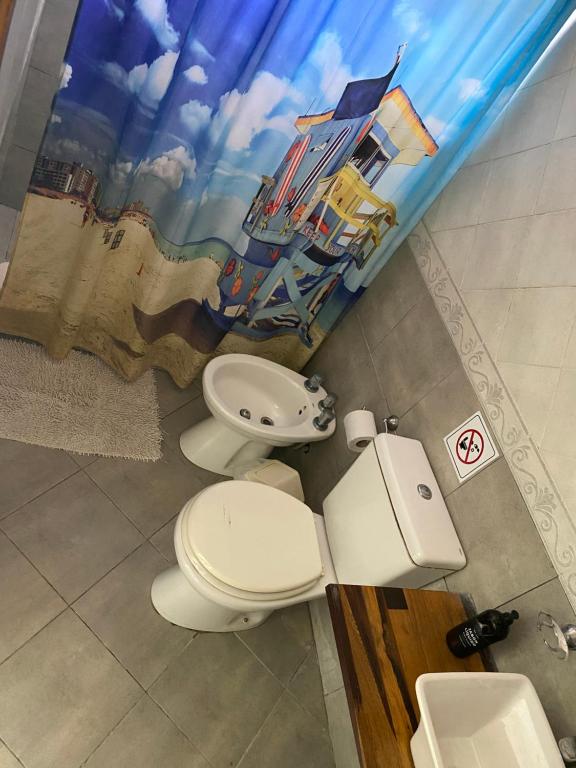 baño con 2 aseos y lavamanos en Liwen Apartamentos de Playa en San Clemente del Tuyú
