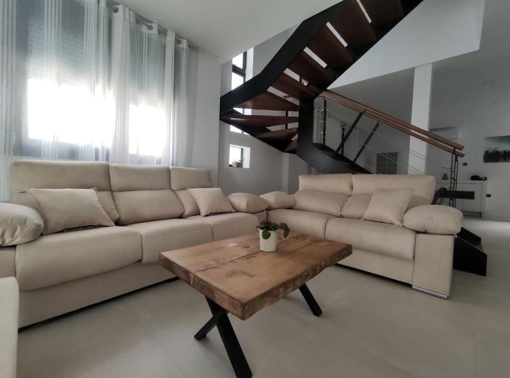 ein Wohnzimmer mit einem Sofa und einem Tisch in der Unterkunft Apartamentos Las Pasaeras in Montehermoso