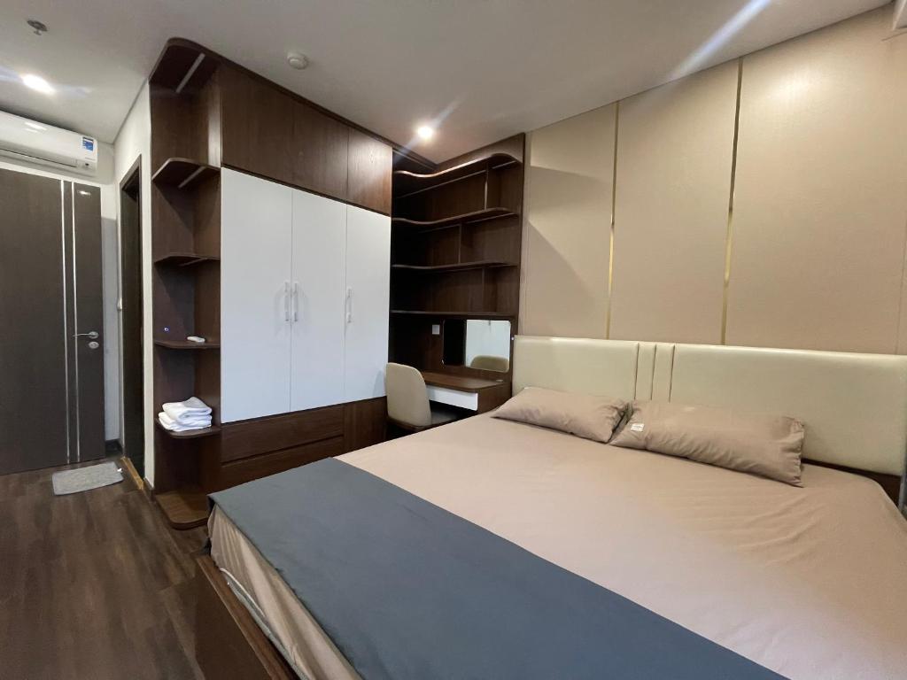 a bedroom with a large bed and cabinets at Homestay Honey Appartment Hải Phòng 2 - Hoàng Huy Grand Tower in Hai Phong