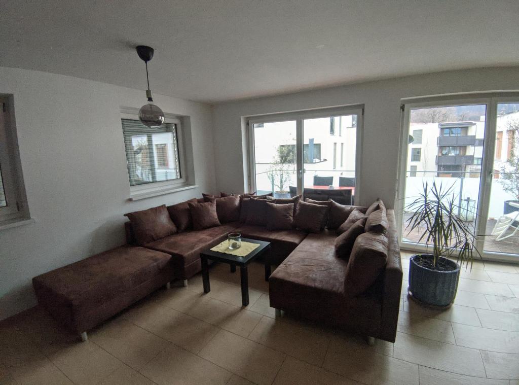 uma sala de estar com um sofá castanho e uma mesa em GrafMax Apartment em Hohenems