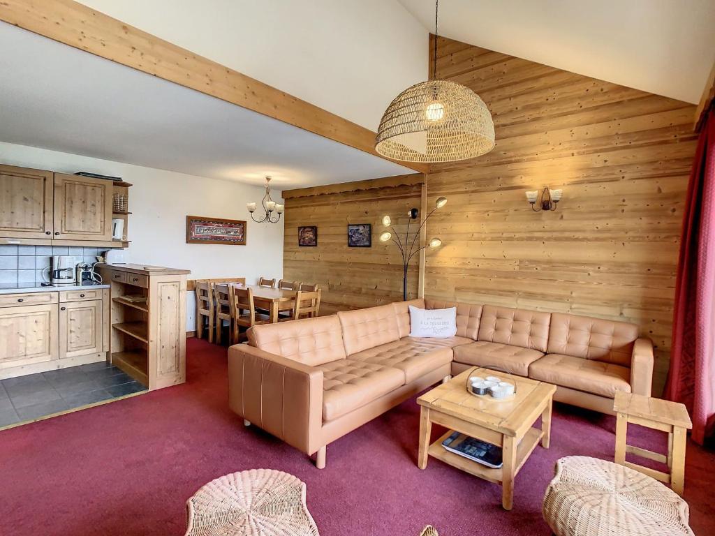 a living room with a couch and a kitchen at Appartement Duplex 8 pers avec Balcon, Piscine, Sauna, Hammam et Parking Privé - Fontcouverte-la-Toussuire - FR-1-417-164 in La Toussuire