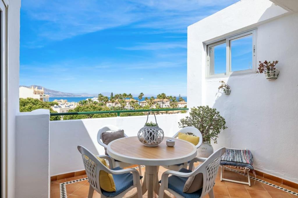 d'un balcon avec une table, des chaises et une fenêtre. dans l'établissement Sea View Apartment at Wyndhams Complex, à Malaga