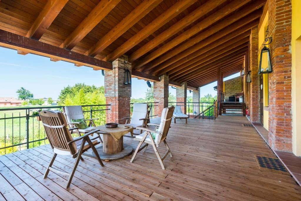 una terraza de madera con sillas y una mesa. en Ardenga Guest House, en Montechiarugolo