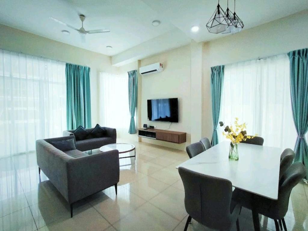 a living room with a table and chairs and a television at GUESTHOUSE #2 Semi Bungalow House in Kuah