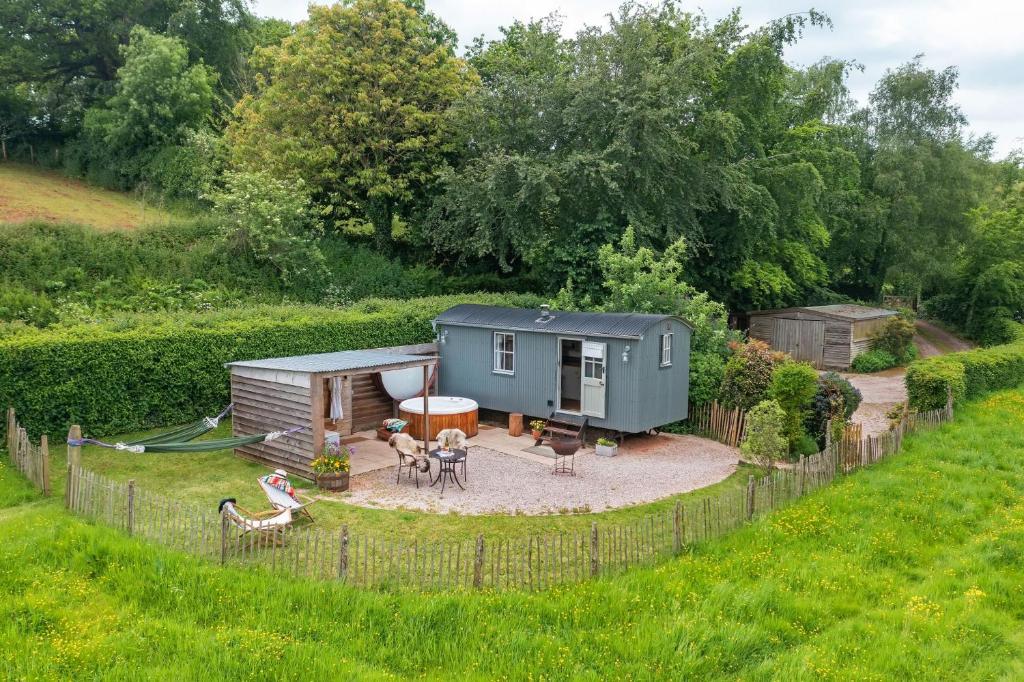 a tiny house in the middle of a yard at Apple Blossom, Devon Hideaways in Kenton