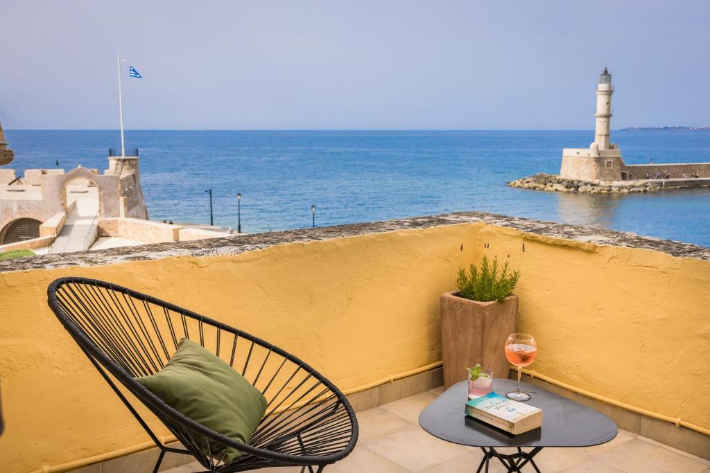 a patio with a chair and a table with a glass of wine at Alcanea Boutique Hotel in Chania Town