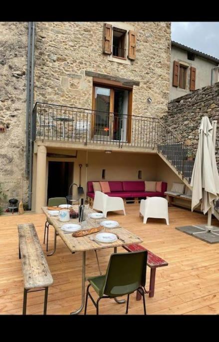 un patio avec une table et des chaises et un bâtiment dans l'établissement Bienvenu « Chez Nous », gîte de charme, à Nant