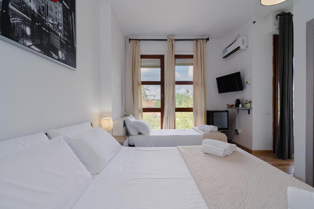 a white bedroom with a large bed and a couch at B&B Elegance in Bologna