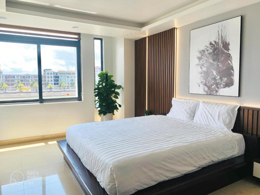1 dormitorio con 1 cama blanca grande y ventana en TaMaDu's House en Ha Long