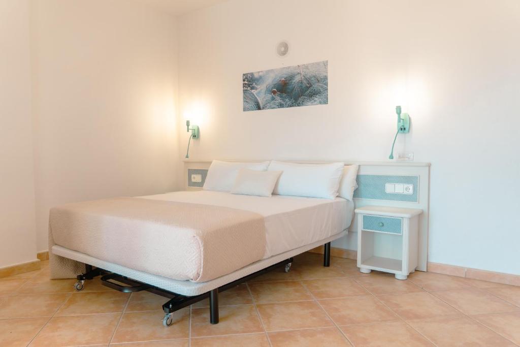 sypialnia z łóżkiem i stolikiem nocnym obok w obiekcie Rosamar Ibiza Hotel w mieście San Antonio Bay